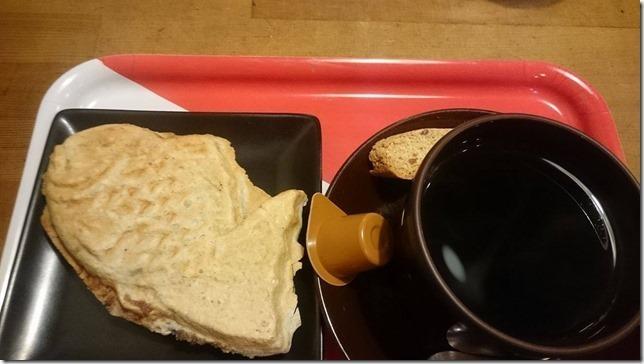 お盆にのったタイヤキとコーヒーの写真